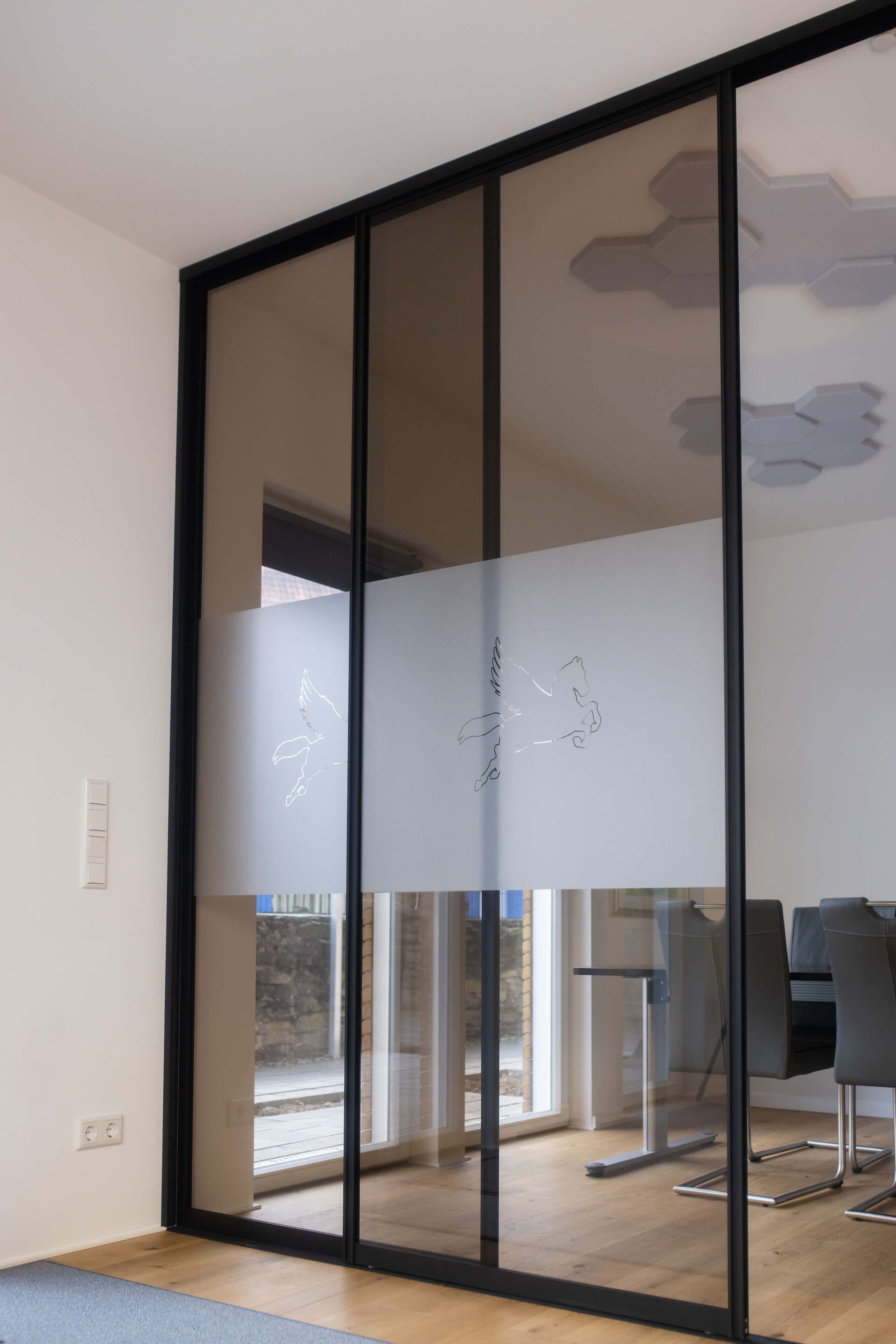 https://cms.hibitaro-relaunch.okeano.dev/uploads/Schiebetueranlage_als_Raumteiler_im_Buero_Bronziertes_Glas_inkl_schwarze_Rahmen_ffe4db1e6e.jpg